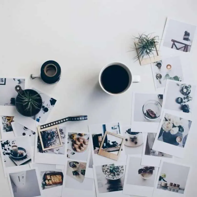 Tazas de café y fotos decorativas en escritorio minimalista con plantas y artículos de diseño.