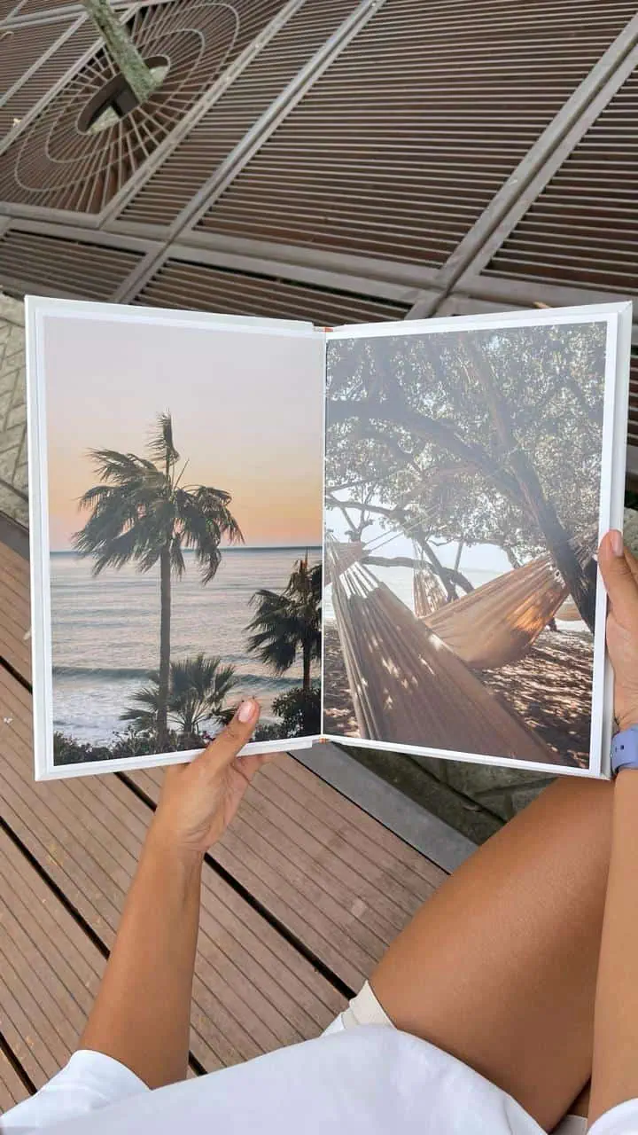 Fotos de un libro con paisajes tropicales en una terraza al aire libre.