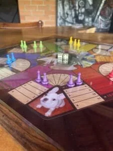 1. Juego de mesa Monopoly con piezas de colores en una mesa de madera.