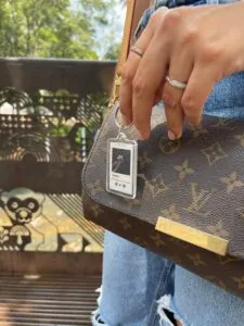 Llavero de lujo con diseño de dispositivo móvil y marca Louis Vuitton.