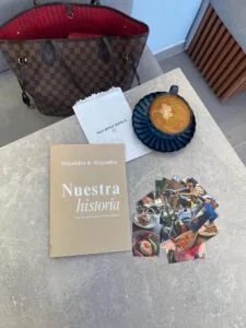1. Bolso de mano Louis Vuitton con interior rojo, en mesa de café.